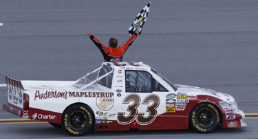 Mike Wallace takes the checkered flag at Talladega in 2011 in the Anderson's Maple Syrup / KHI Chevy Silverado.